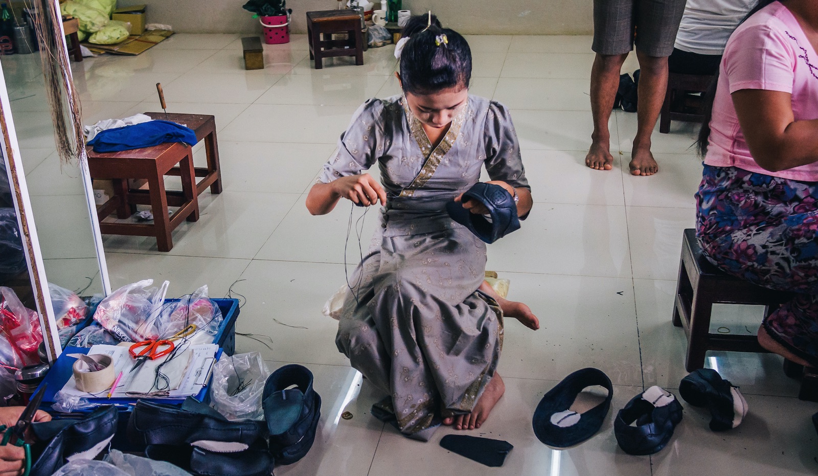 Burmese female migrant workers sewing or stitching leather shoes in footwear production line of factory in Sankhlaburi, Kanchanaburi, Thai-Burma border province.