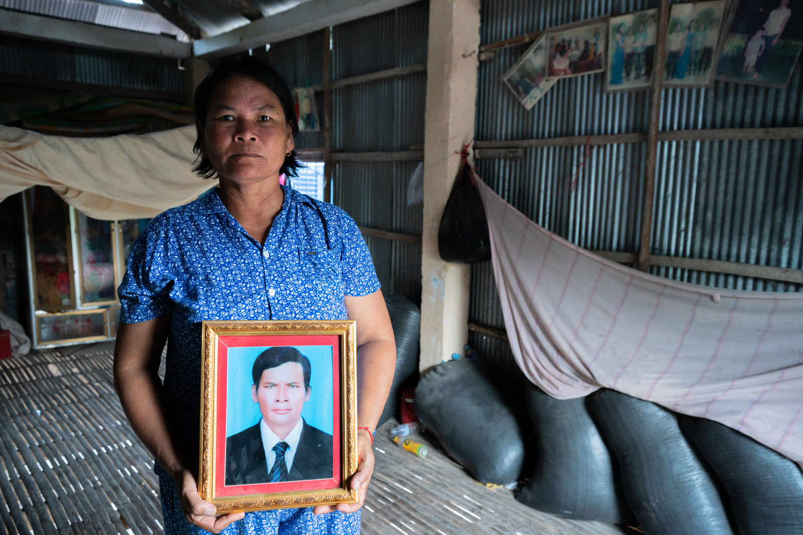 Kat Chang poses for a portrait in her home with a picture of her late husband Toun Sarith, who died of rabies. Andy Ball