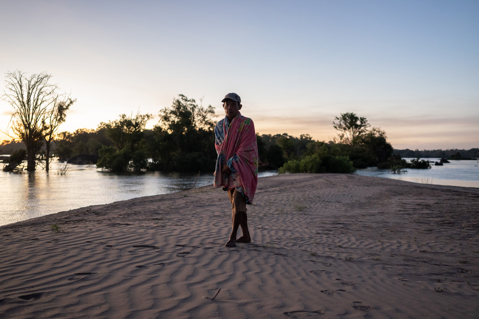A community fishery patroller wakes up on a sandbank in the Mekong River that the team had been camping on while on the lookout for illegal fishers.