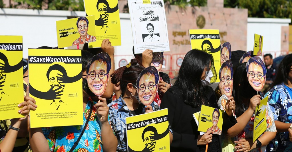 Protesters hold up face masks of Wanchalearm’s likeness during a demonstration in front of the Cambodian Embassy in Bangkok on 3 December 2020 to mark six months since Wanchalearm’s disappearance.