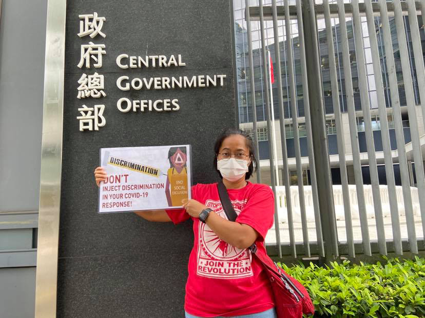 Sringatin, chairperson of the Indonesian Migrant Workers’ Union, holds a banner in protest of discriminatory COVID-19 policies outside Hong Kong’s Central Government offices in June 2021. IMWU
