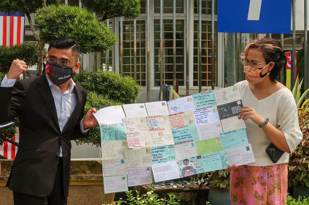 An aide for Selangor chief minister Amirudin Shari (L) meets Klima Action Malaysia campaigner Nicole Fong outside the Selangor State Secretariat in September 2021.